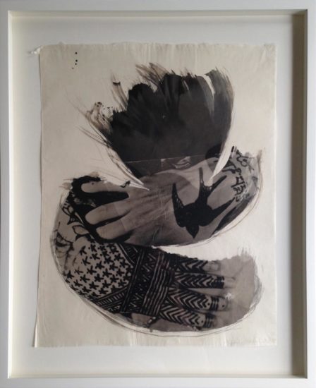 Palladium work of a woman's hands with tattoos. Above her hands is a photograph of a bird in flight.